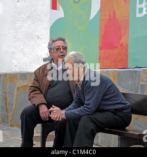 Due uomini anziani in chat su banco, Casares, la provincia di Cadiz Cadice, Andalusia, Spagna, Europa occidentale. Foto Stock