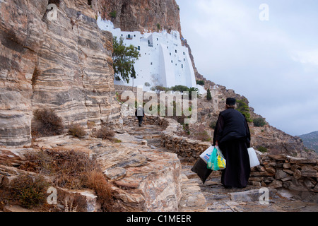 Sacerdote ortodosso sulla scalinata che conduce al monastero di Chozoviotissa sul Greco Cyclade isola di Amorgos. Foto Stock