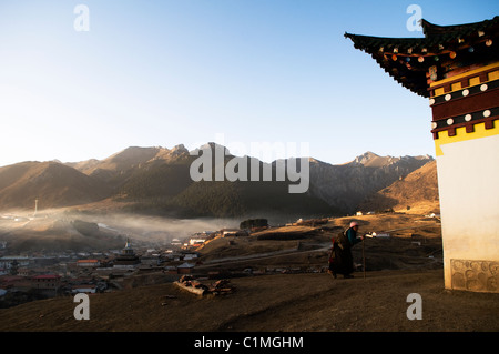 La mattina presto in Langmusi, Cina. Il Tibetano pellegrini a piedi su per la montagna su un locale Kora percorso intorno Langmusi. Foto Stock