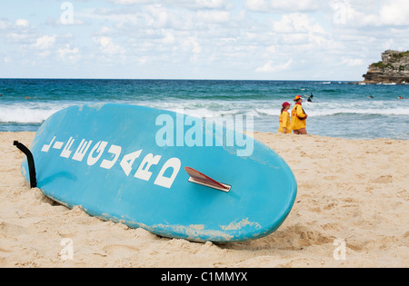Bagnino di salvataggio con la tavola da surf in spiaggia Foto Stock