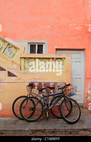 Biciclette su grunge tropicali dei Caraibi Orange facciata gialla Messico Foto Stock