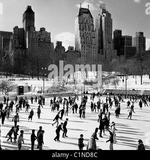 America, 1950s. Una fotografia da J Allan contanti. I pattinatori godetevi il ghiaccio nel Central Park di New York. Foto Stock