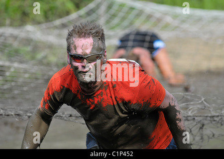 I concorrenti splash attraverso il pozzo del fango al 2010 Phitathalon in Marysville, Ohio Foto Stock