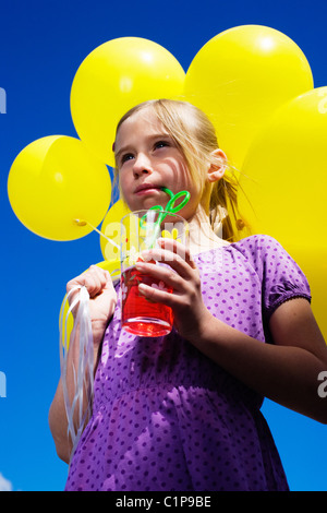 Basso angolo vista della ragazza con mazzo di palloncini Foto Stock