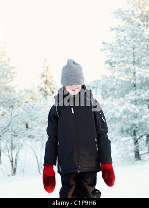 Ragazzo che indossa wooly hat nel paesaggio invernale Foto Stock