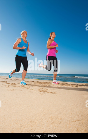 Due donne jogging sulla spiaggia Foto Stock