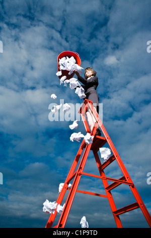 Donna buttare la spazzatura dal recipiente rosso permanente sulla scaletta Foto Stock