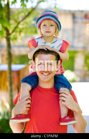 Ritratto di ragazza sulle spalle dei padri in strada Foto Stock