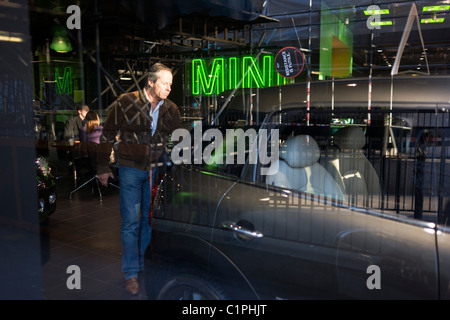 Interessato potenziale acquirente esplora un Mini concessionaria auto di Park Lane a Londra. Foto Stock