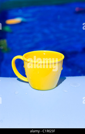 In plastica gialla tazza di tè su blu Foto Stock