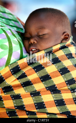 Bambino trasportato su madre torna, Senegal Africa Foto Stock