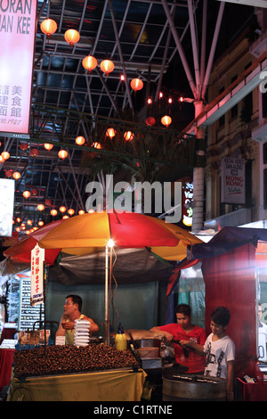 Venditore a vendere arrosto di castagni in Jalan Petaling a Chinatown. Foto Stock