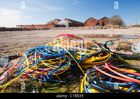 Furto di cavi in rame che è stato strappato da ladri e la plastica abbandonati sulla massa di rifiuti in Barrow in Furness. Foto Stock