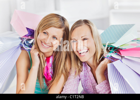 Il piacere di due donne azienda shopping bags sorridente verso la telecamera Foto Stock