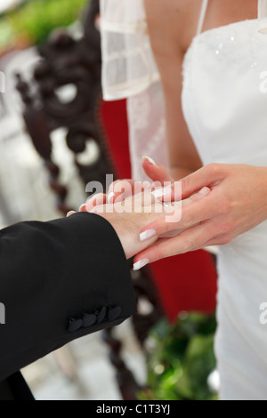 Sposa di mettere l'anello di matrimonio su sposa stallieri dito Foto Stock