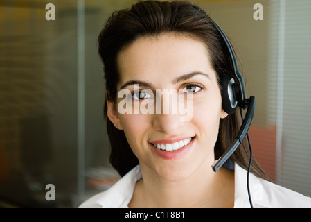 Donna che indossa cuffia telefonica, ritratto Foto Stock