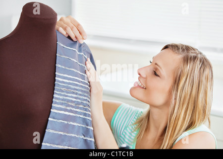 Incandescente donna abiti da cucire in cucina Foto Stock