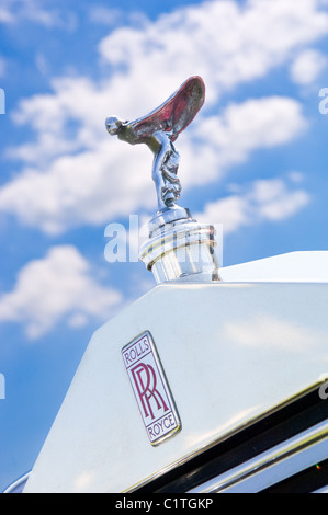 La Rolls Royce spirito di ecstasy montato sul cofano / cappa, contro un cielo blu con nuvole cumulus. Foto Stock