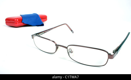 Una coppia di borgogna gli occhiali da lettura su un bianco di fondo tagliato con un rosso custodia per occhiali e panno blu per pulizia. Foto Stock