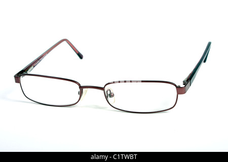 Una coppia di borgogna gli occhiali da lettura su un bianco di fondo tagliato con un rosso custodia per occhiali e panno blu per pulizia. Foto Stock