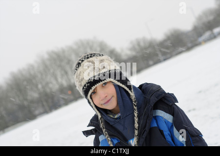 Ragazzo giovane avvolto per le basse temperature Foto Stock