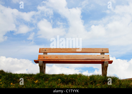 Lone,vuoto panca in legno di fronte a un bel cielo blu, il concetto di una panca in cielo, un luogo per rilassarsi Foto Stock