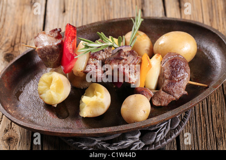La carne di cervo shish kebab e nuove patate su una padella Foto Stock