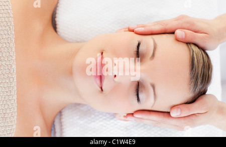 Giovane donna rilassata ricevere un massaggio della testa Foto Stock