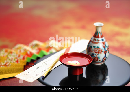 Saki bottiglia con una striscia di carta su un vassoio Foto Stock