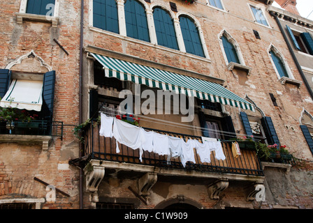 Un esterno colpo di appena lavati i vestiti di bianco sulla linea di appendimento al di fuori di un balcone a Venezia, Italia. Foto Stock