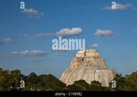 La piramide del mago (Pirámide del Mago) cresta sopra le cime degli alberi nella città maya di Uxmal, Messico. Foto Stock