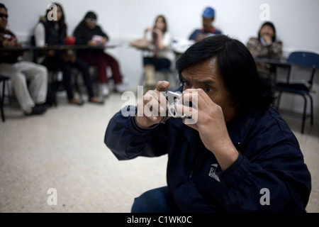 Un fotografo cieco prende le immagini come egli si inginocchia a un workshop di fotografia per ipovedenti e non vedenti in Città del Messico Foto Stock