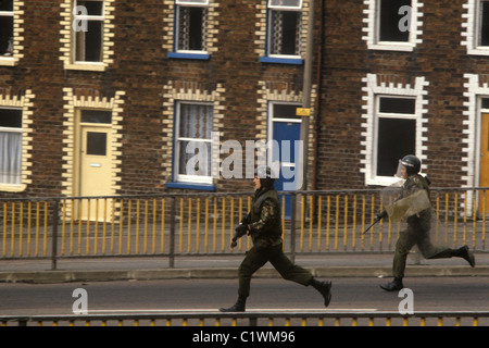 Esercito britannico armate in Irlanda del Nord i guai degli anni ottanta dà la caccia ai disordini di giovani. Belfast 1981 HOMER SYKES Foto Stock