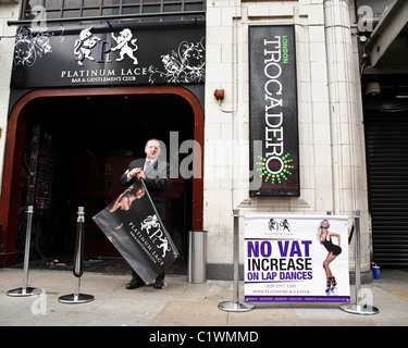 26/03/2011. Un uomo mette segno pubblicità fuori un lap dancing club in Coventry Street, Londra. Foto Stock