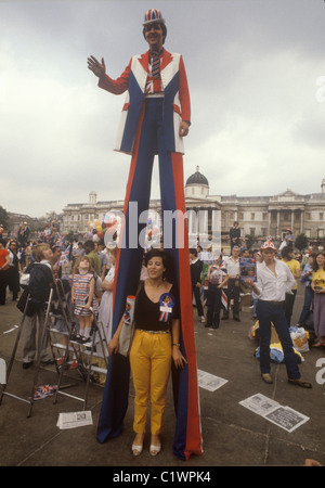 Matrimonio reale del principe Carlo e di Lady Diana Spencer Trafalgar Square uomo patriottico che utilizza palafitte per vedere la folla. Bambini sulle scale che cercano di vedere anche la processione. Luglio 1981 1980 nel Regno Unito HOMER SYKES Foto Stock