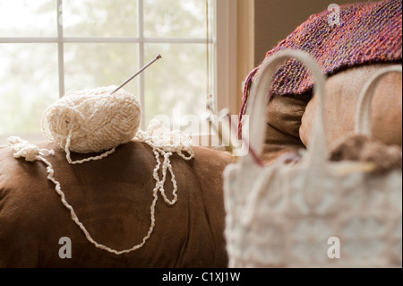 Soggiorno con filato per maglieria e fornisce su un lettino di marrone Foto Stock