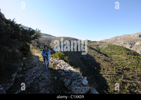 Escursionista sul sentiero mozarab, originariamente un mulo moresco trail, vicino a Benimaurell, Vall de Laguart, provincia di Alicante, Valencia, Spagna Foto Stock