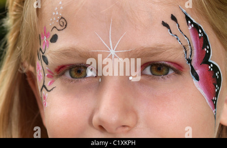 Giovane ragazza farfalla dipinta sul viso Foto Stock