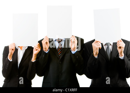 Fila di tre business partner per nascondere i loro volti dietro fogli vuoti Foto Stock