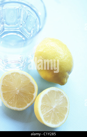 I limoni e vetro su uno sfondo blu Foto Stock