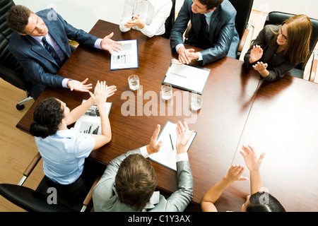 Al di sopra di colpo di happy business partner plaudendo a certi leader in riunione Foto Stock