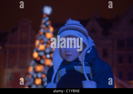 Ragazza giovane, portato piggyback dal genitore, guardando la vigilia di Capodanno concerto all'aperto a Rynek di Wroclaw, Bassa Slesia, Polonia Foto Stock