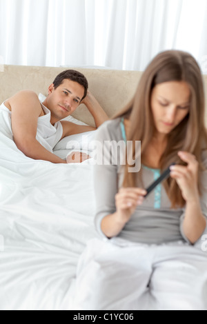 Adorabili uomo che guarda la sua ragazza il deposito il suo dito unghie sul letto Foto Stock