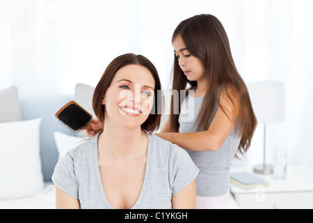 Bella figlia spazzolando la madre Foto Stock