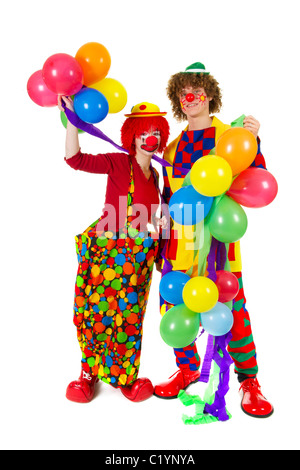 Giovane divertente pieno vestito clown con molti palloncini Foto Stock