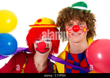 Giovane divertente pieno vestito clown con molti palloncini Foto Stock