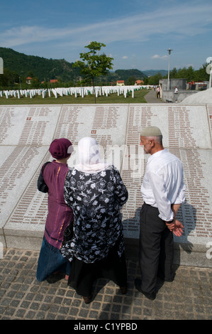 Bosniaci lettura muro dei nomi a Srebrenica Potocari monumento e cimitero per le vittime del genocidio del 1995 nella parte più orientale della Republika Srpska, un'entità della Bosnia-Erzegovina. Più di 8,000 musulmani bosniaci sono stati uccisi dopo che l'esercito serbo bosniaco ha attaccato Srebrenica, un'area sicura dell'ONU, il 10-11 luglio 1995, nonostante la presenza di soldati di pace dell'ONU. Foto Stock