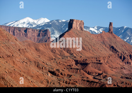 VISTA AEREA. Monoliti di arenaria rossa di Castle Rock e le montagne innevate di la SAL. Moab, Grand County, Utah, USA. Foto Stock