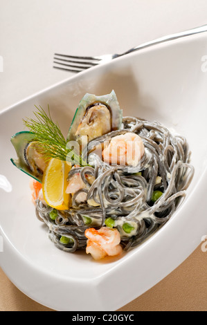Piatti a base di frutti di mare freschi nero seppia coulored spaghetti tipico cibo italiano