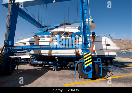 Barca sollevato su un portatile barca paranco a marina di Puerto Pollensa, Mallorca, Spagna Foto Stock